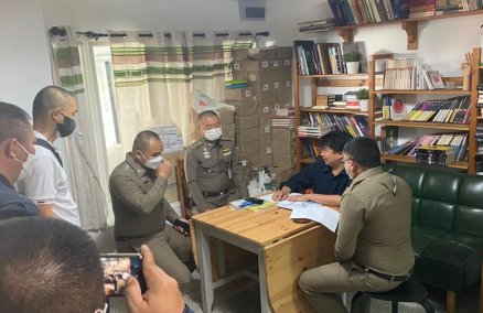 Fa Diew Kan editor Thanapol Eawsakul, seated in a blue shirt, talks Thursday morning to the police raiding his office. Photo: Fa Diew Kan